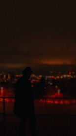 A cinematic silhouette of ekonight against a foggy cityscape at night, bathed in deep crimson hues.