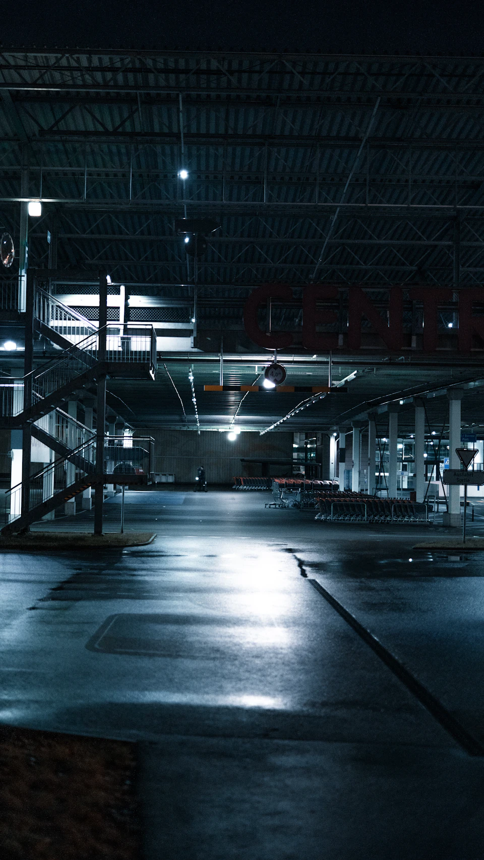 Large empty warehouse with concrete floor and metal beams supporting the ceiling indoors