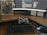 A workspace featuring a curved monitor displaying a software development environment. In front of the monitor is a classic-style mechanical keyboard and a game controller resting against the screen, with a mouse to the side. A notebook with a sci-fi or gaming theme is placed next to the monitor. Sticky notes with handwritten reminders are posted on the wall behind the desk.