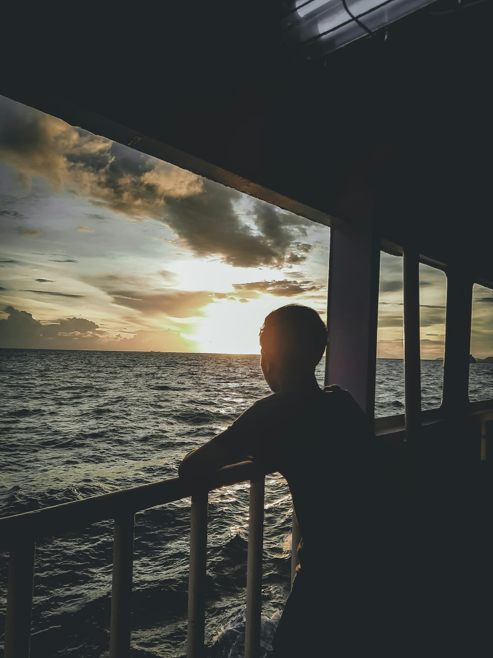 Ein Mann steht auf einem Balkon mit Blick auf den Ozean