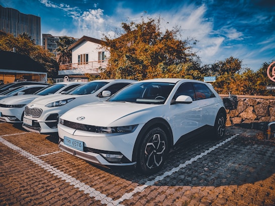 A diverse lineup of vehicles parked in a modern parking lot.