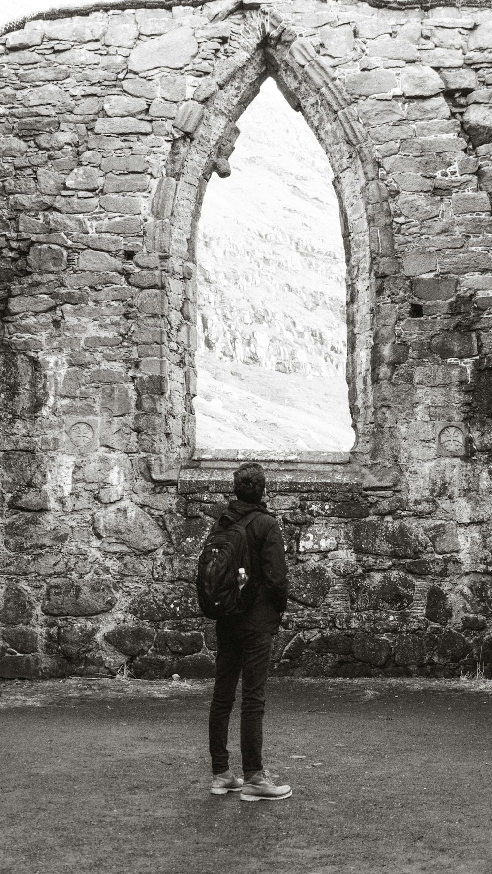 a person standing in front of a stone building