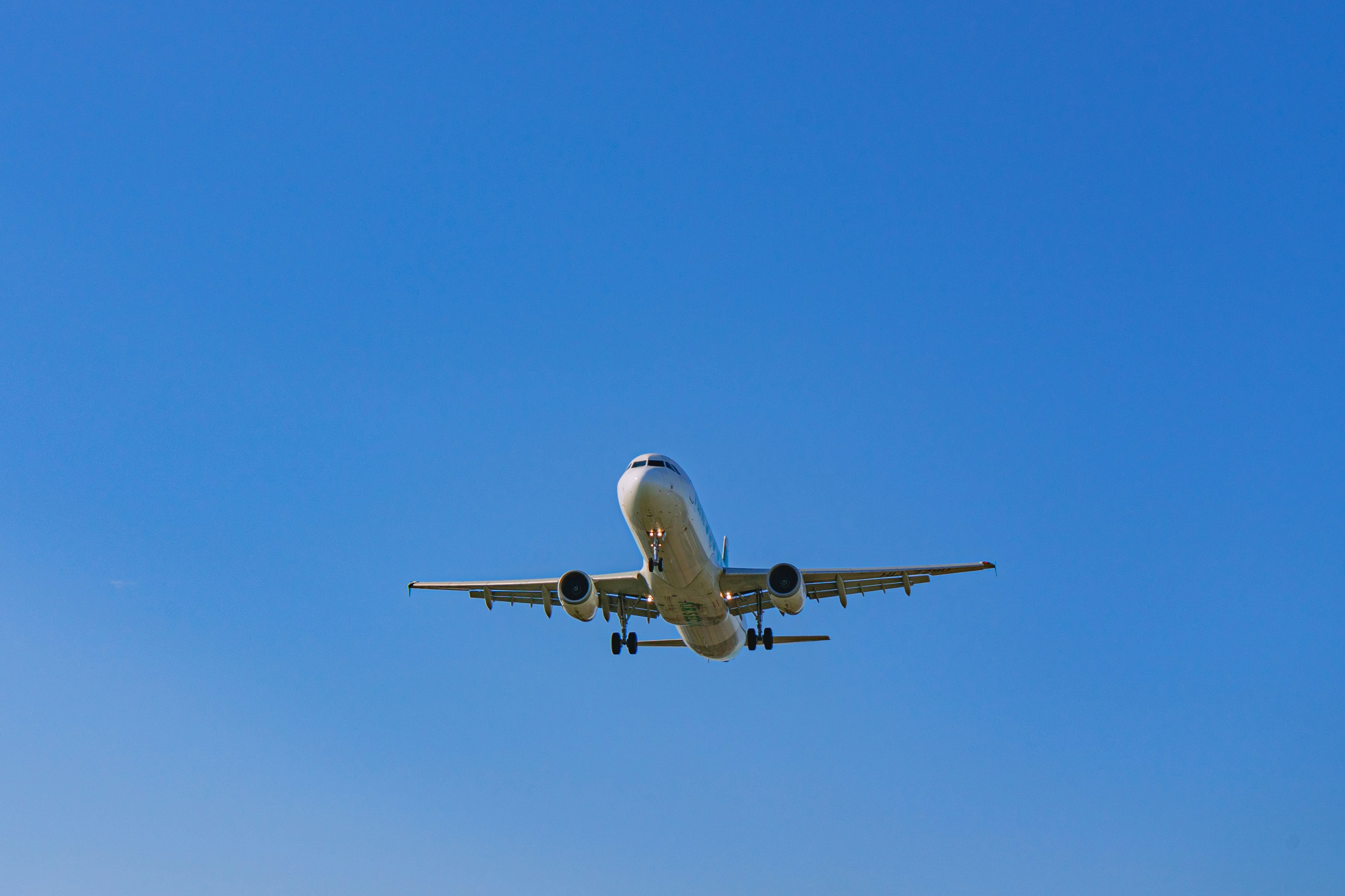 a large jetliner flying through a blue sky, 