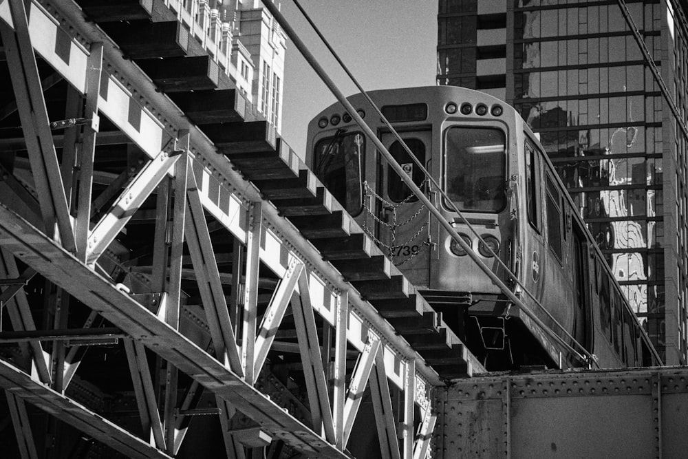 a black and white photo of a train going over a bridge