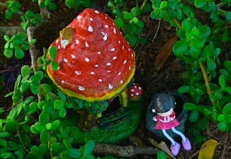 A close-up of a tiny gouache painting featuring a whimsical gnome nestled among autumn leaves.