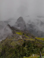 A mystical fog enveloping the ancient ruins in the mountains.