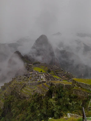 A mystical fog enveloping the ancient ruins in the mountains.