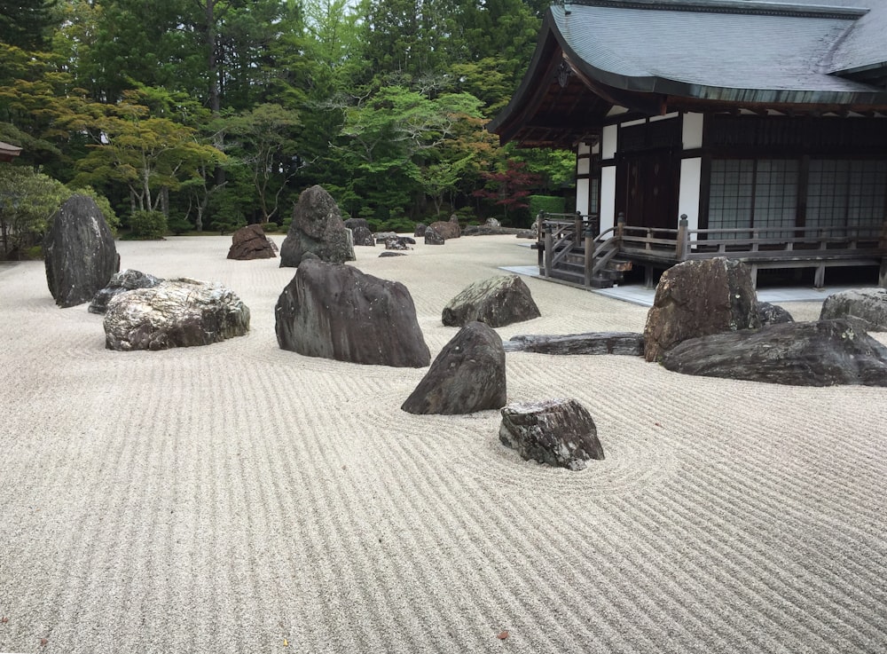 a japanese garden with rocks and a building