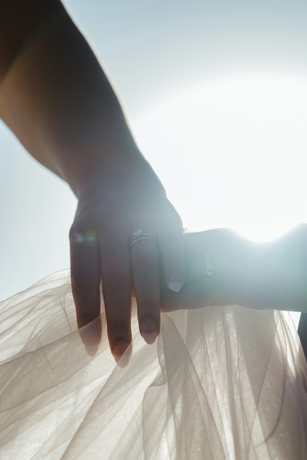 a woman's hand holding onto a white dress