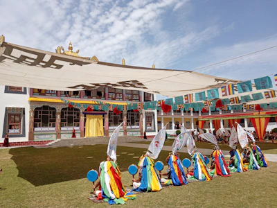 A candid shot of guests enjoying a lively cultural dance in a sunlit courtyard with colorful murals.