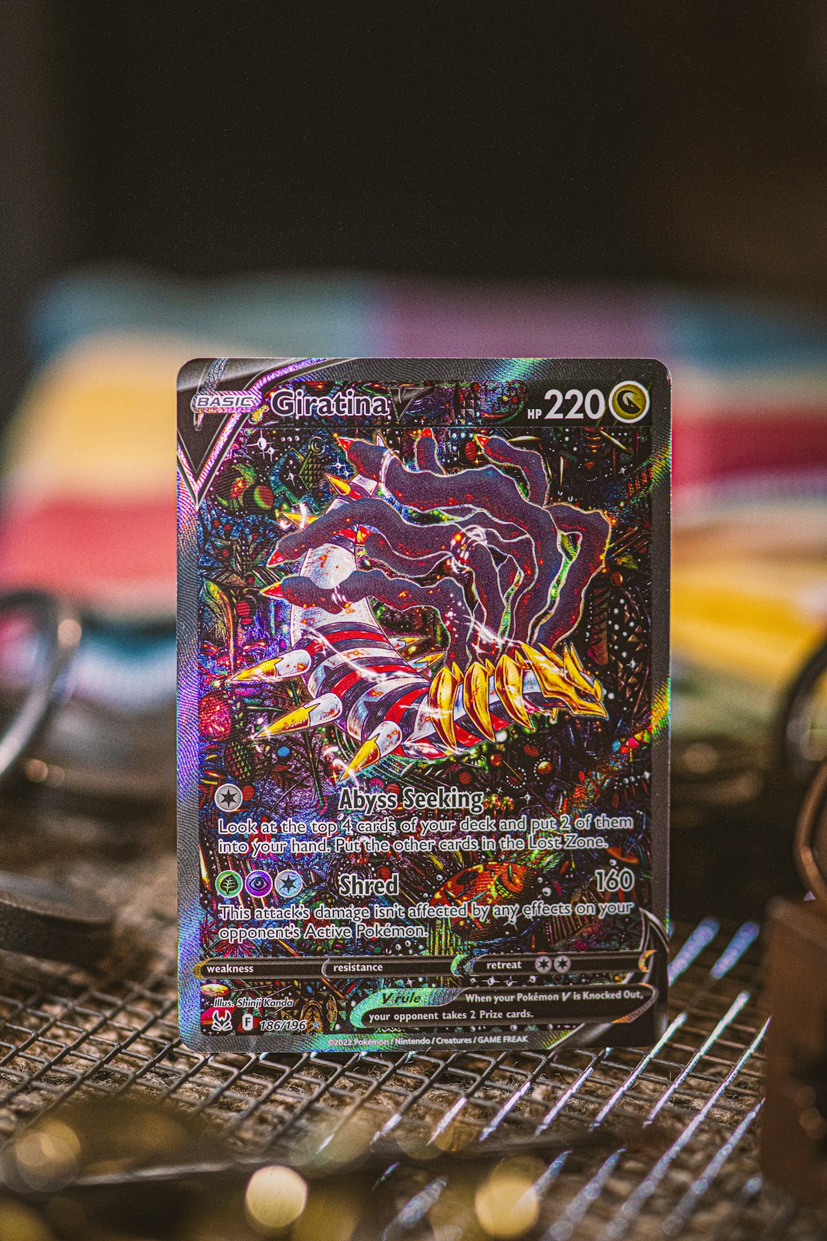 Single holographic Pokemon trading card photographed close up on dark surface showing collector-grade detail