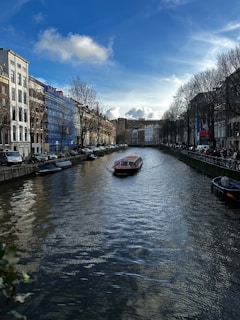 una barca che percorre il fiume kaizergraacht accanto ad alti edifici ad Amsterdam