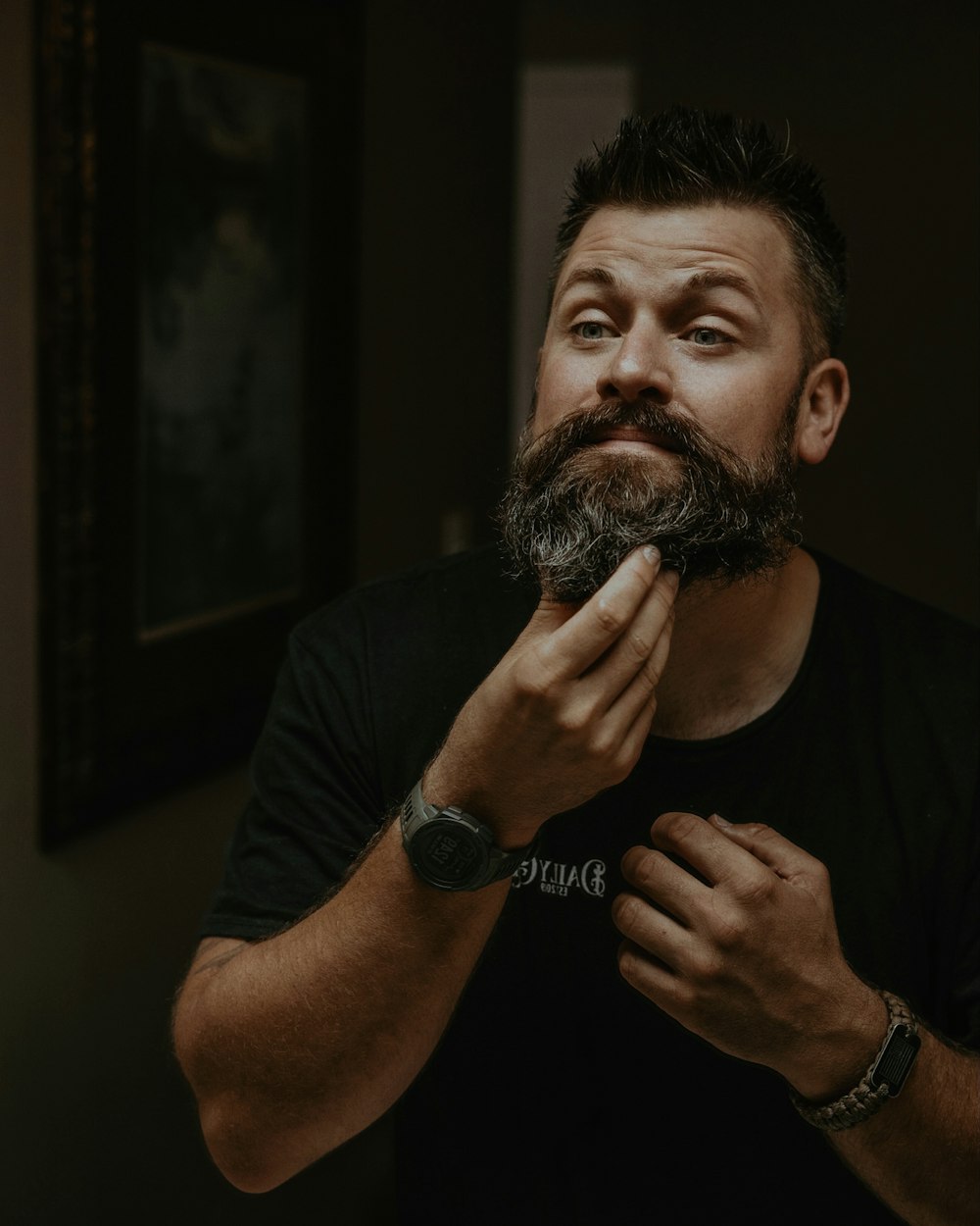 a man is shaving his beard in the mirror