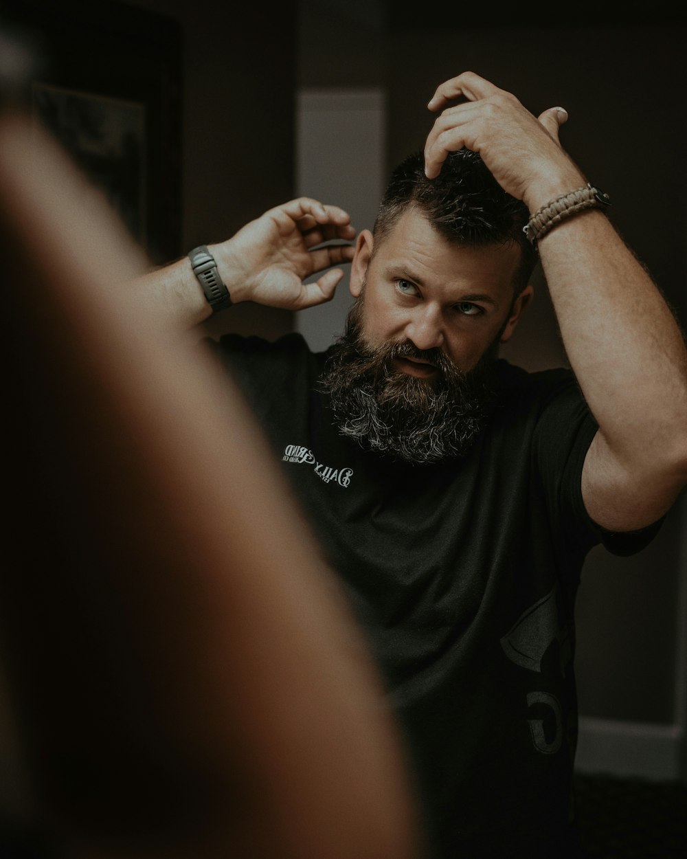 a man with a goatee combing his hair