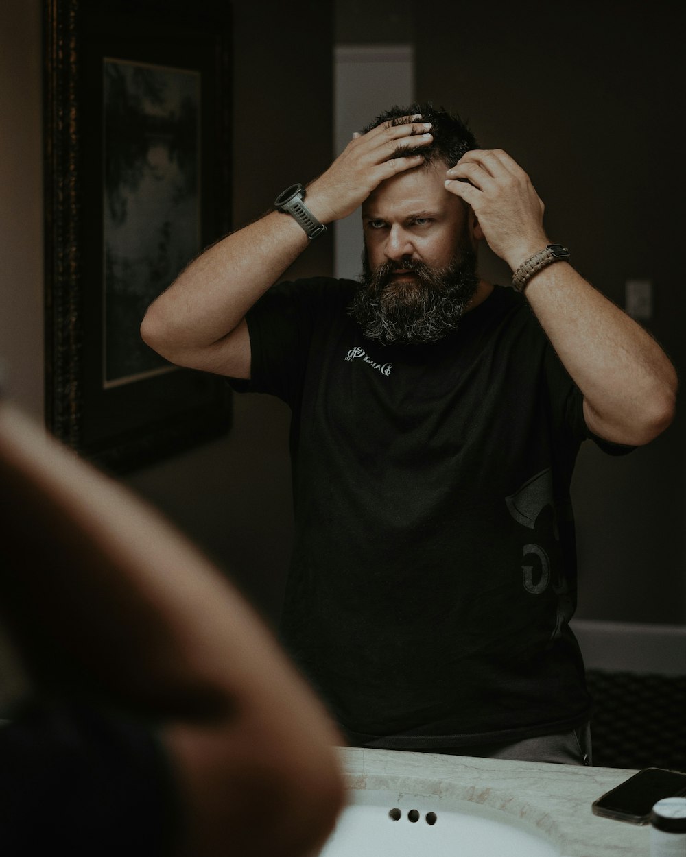 a man with a beard standing in front of a mirror