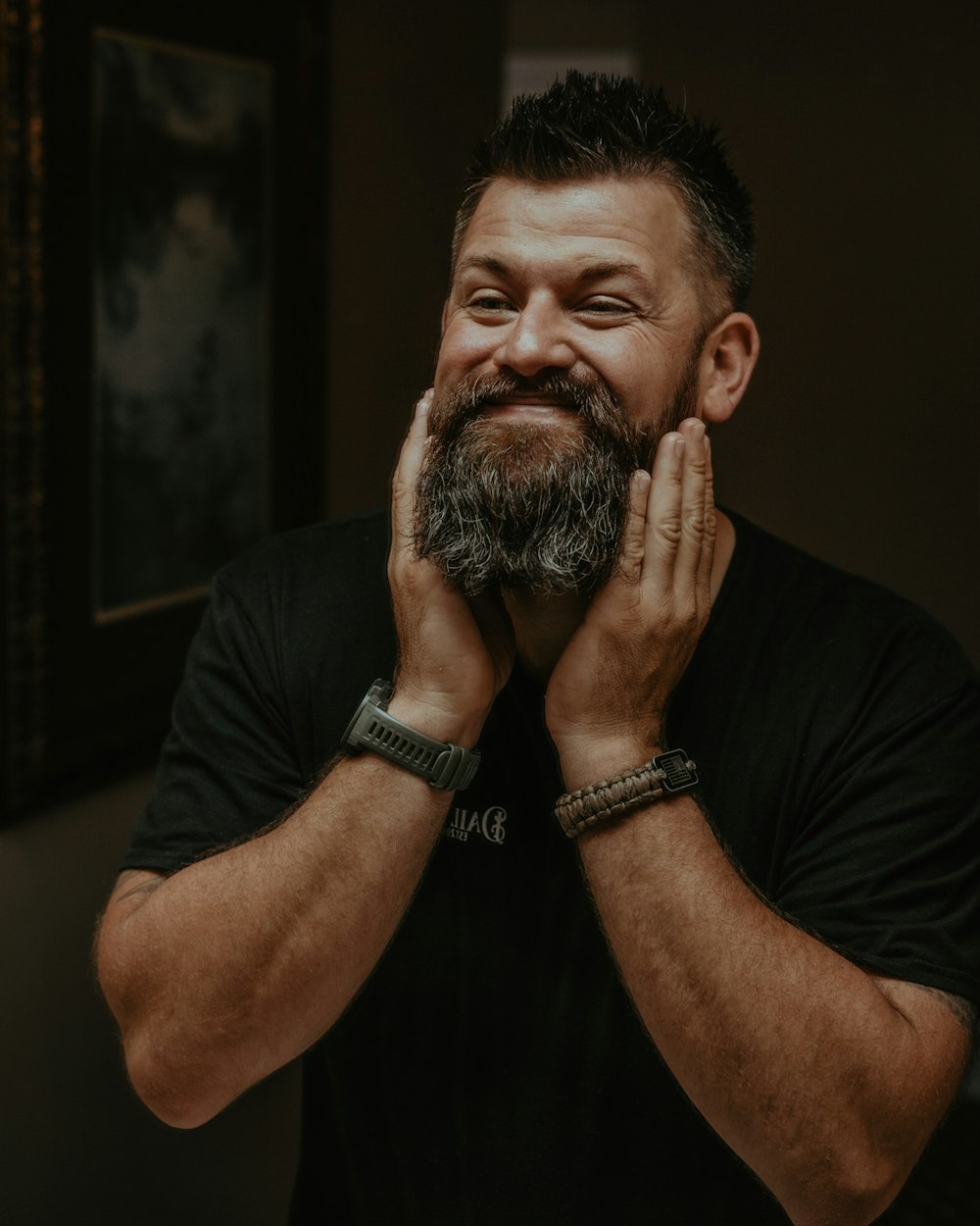 a man with a beard and bracelets is smiling