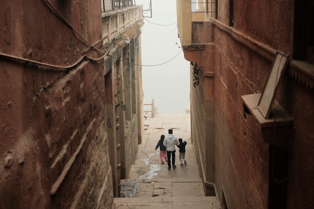 a couple of people walking down a narrow alley way