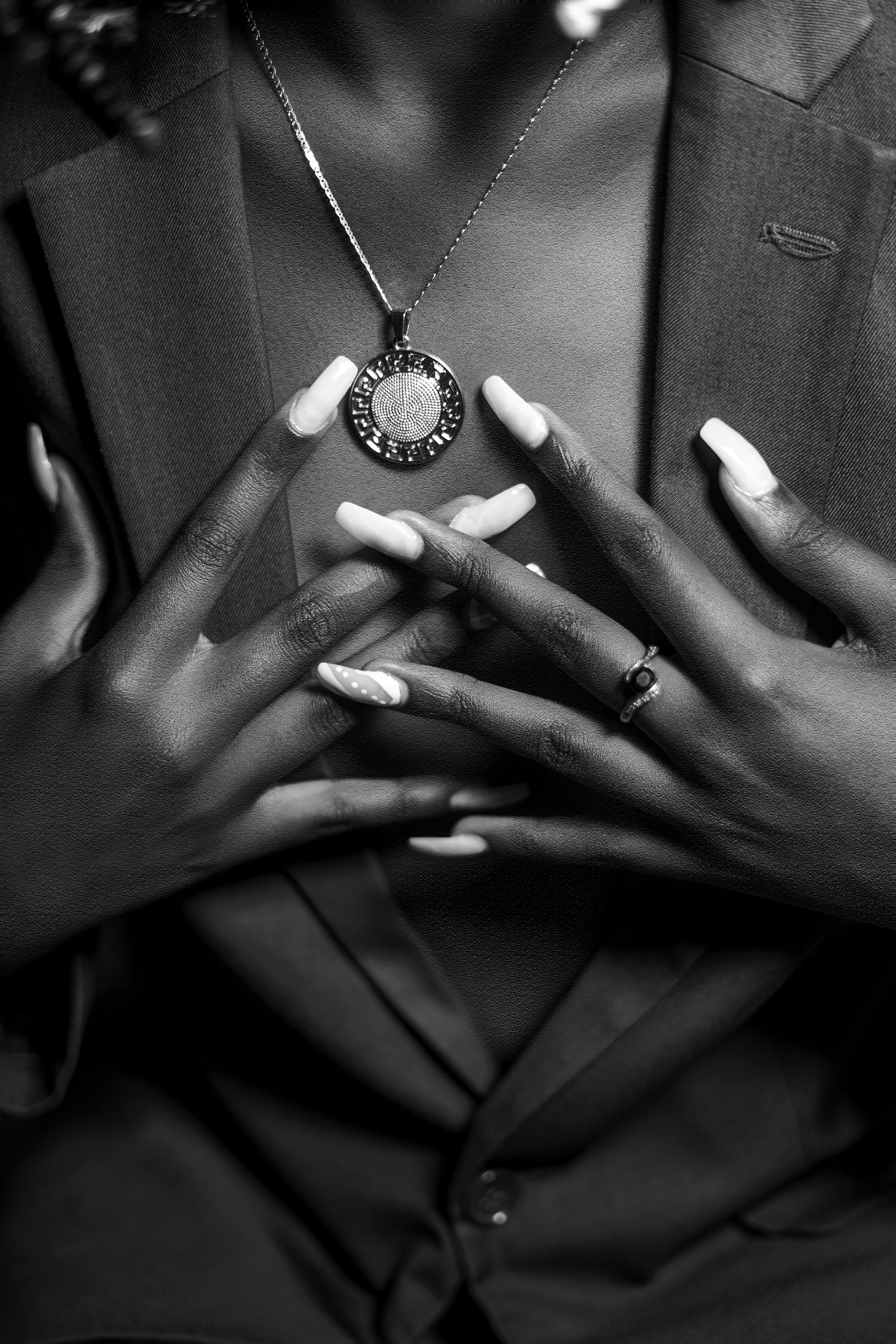 a woman wearing a suit and holding onto a necklace