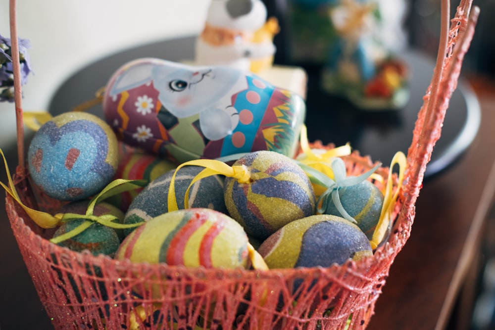 a basket filled with lots of colorful decorated eggs