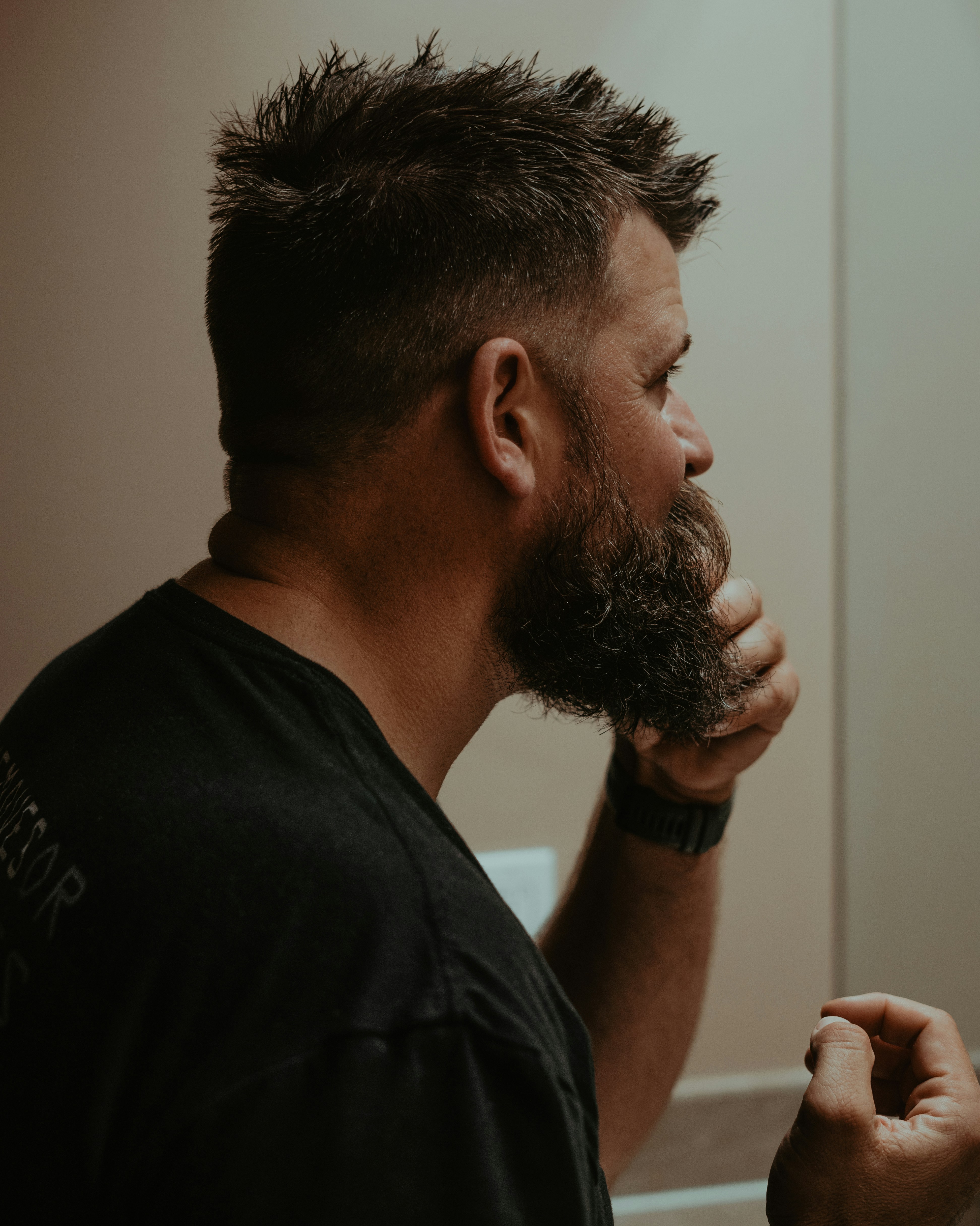 a man with a goatee combing his hair