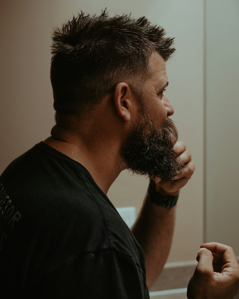 a man with a goatee combing his hair