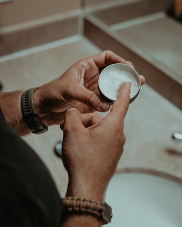 a man holding a bowl of cream in his hand