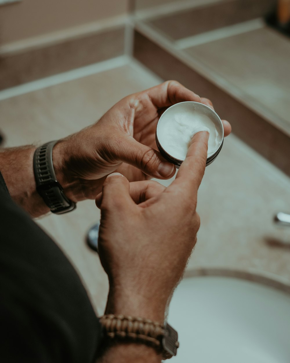 a man holding a bowl of cream in his hand