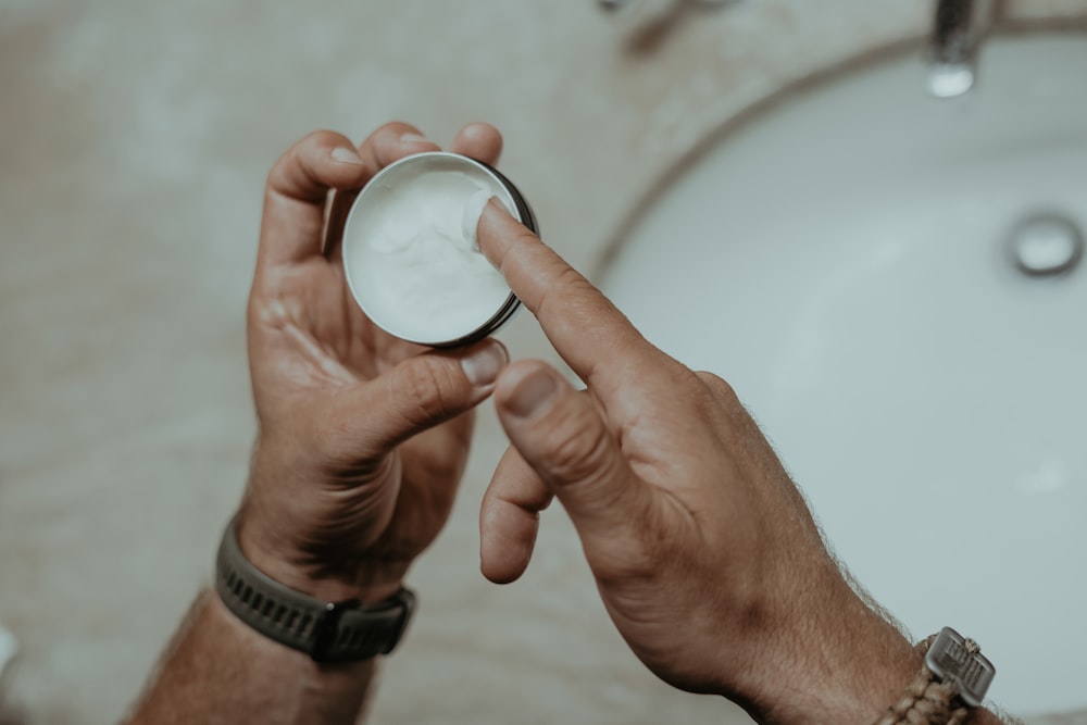 a man holding a bowl of cream in his hand