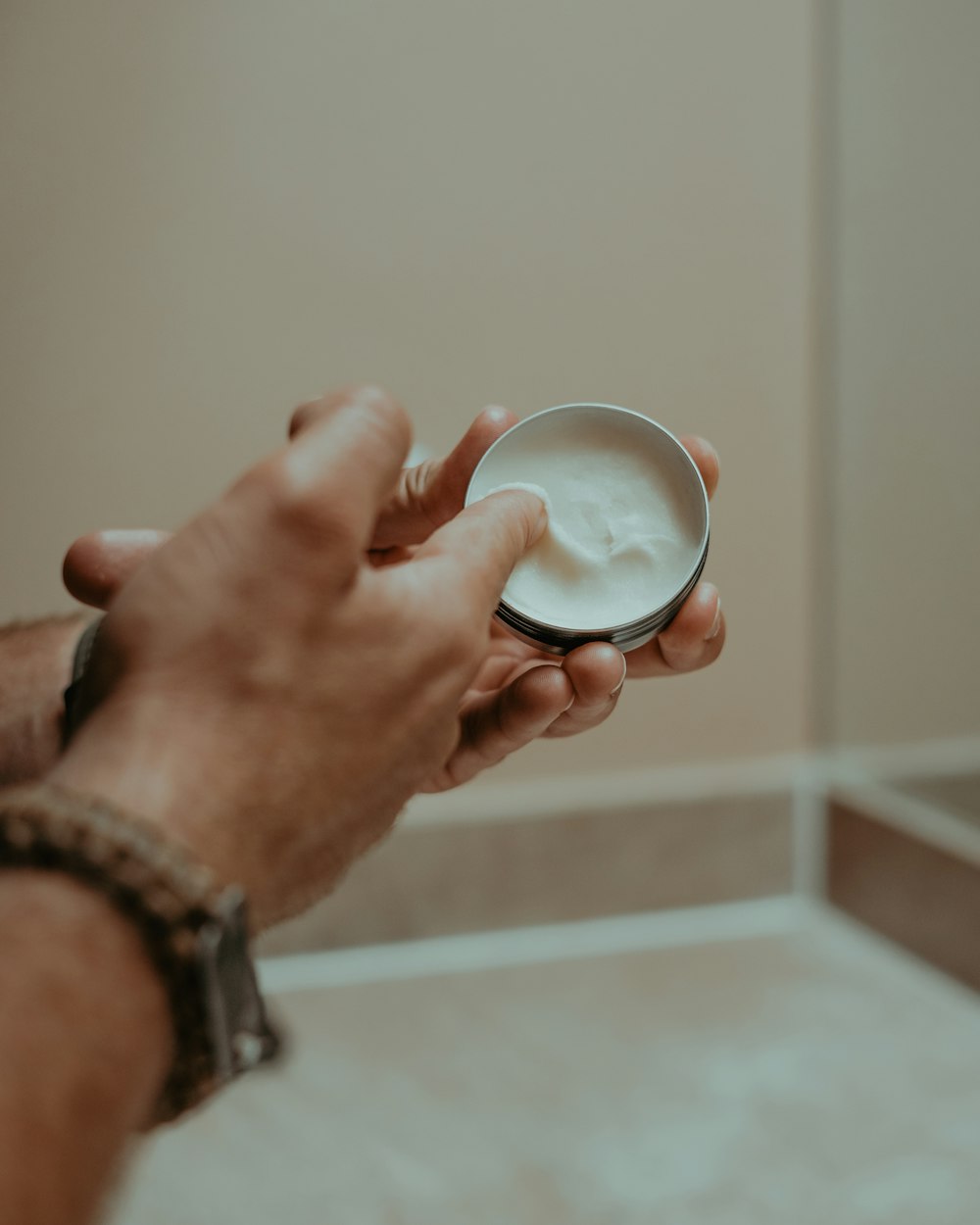 a person holding a bowl of cream in their hand