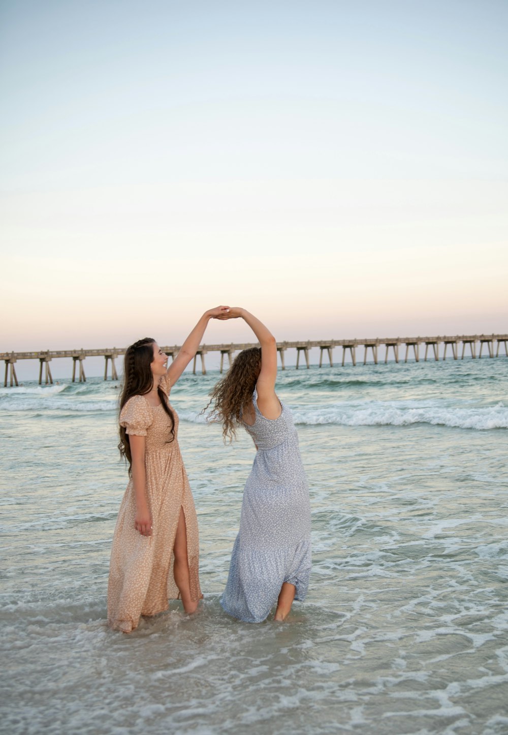 two women standing in the water at the beach