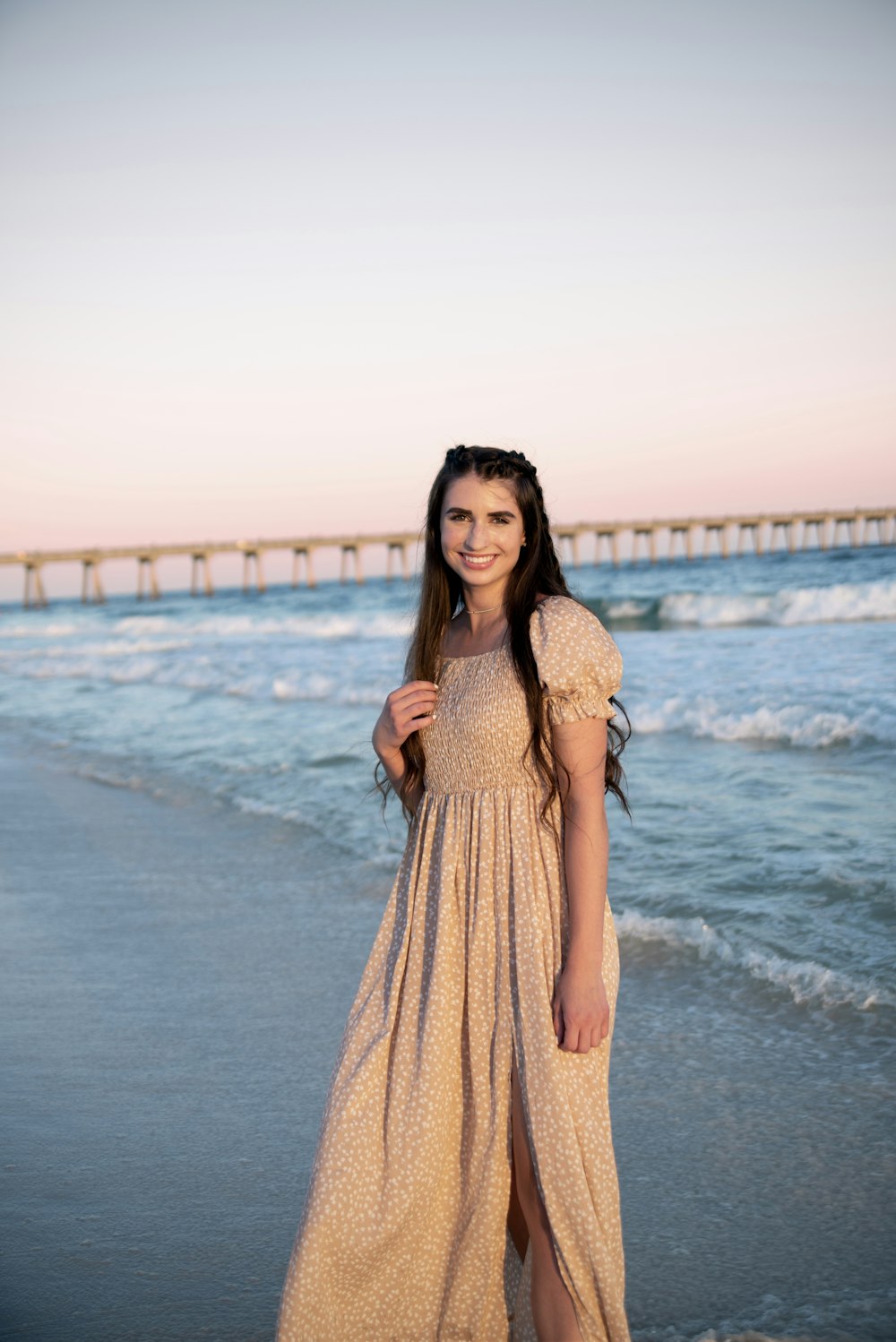 a woman standing on a beach next to the ocean