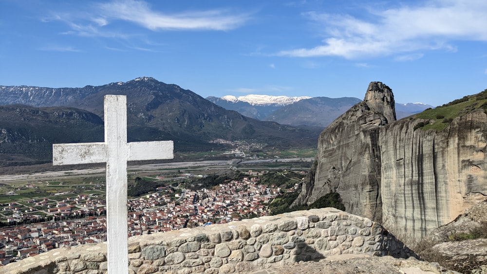 a white cross on top of a stone wall