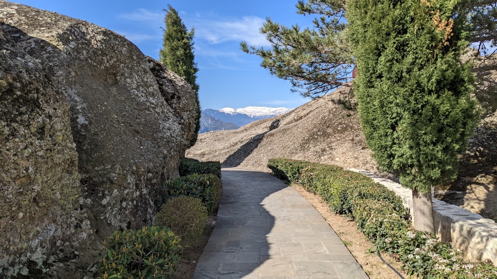 a path between two large rocks with a mountain in the background