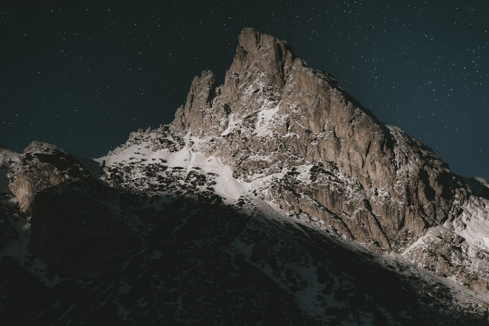 a snow covered mountain under a night sky