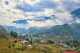 Rolling green hills and terraced fields under soft sunlight.