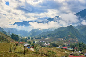 Rolling green hills and terraced fields under soft sunlight.