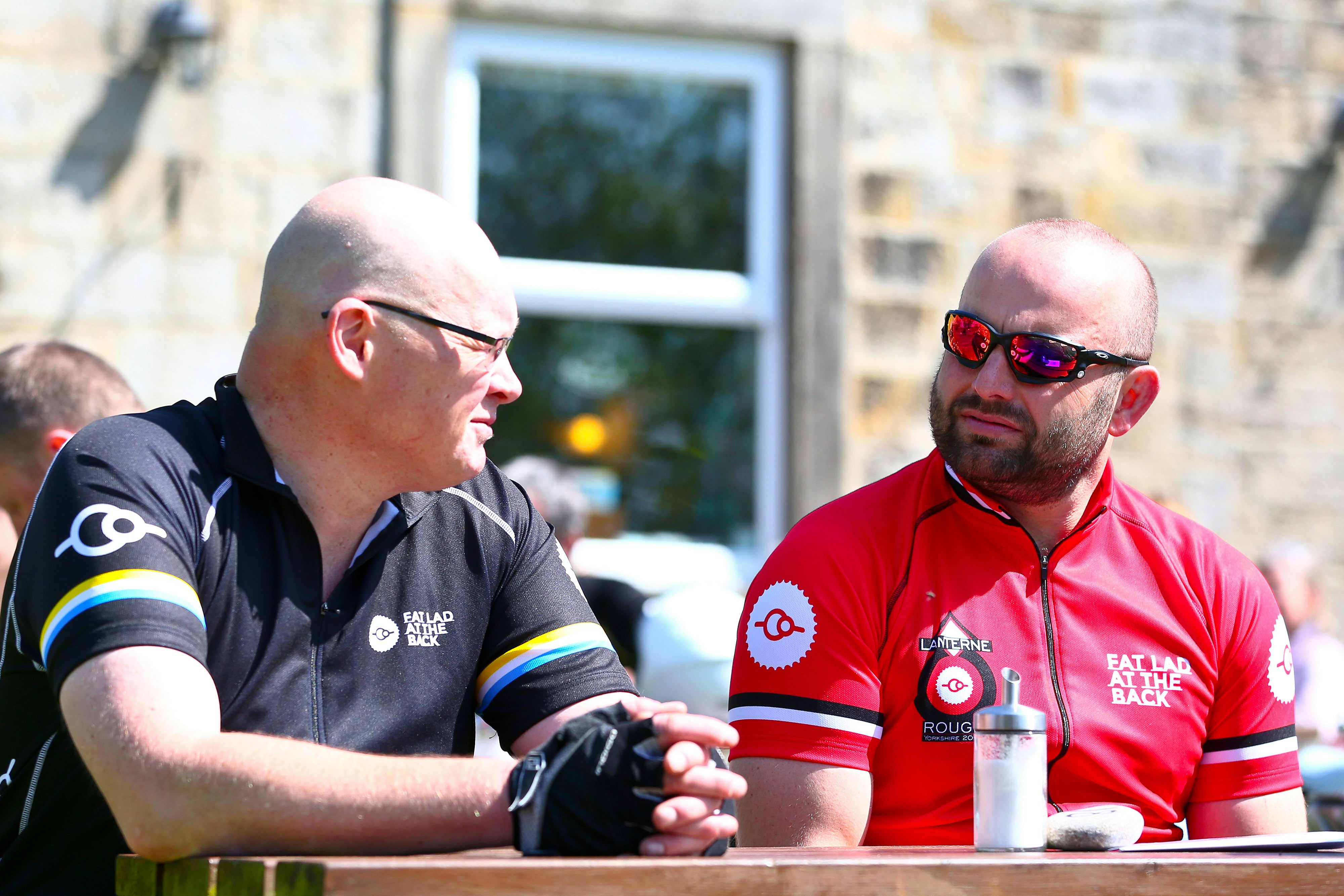 two men sitting at a table talking to each other