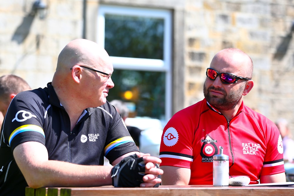 two men sitting at a table talking to each other