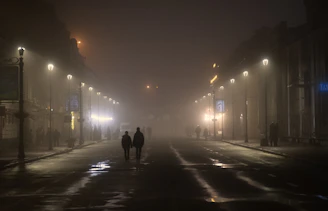 A misty ghost town street with flickering lanterns and shadowy figures.