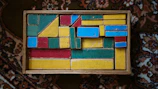 Close-up of colorful wooden blocks arranged in creative patterns on a soft beige rug.