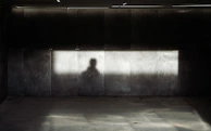 Abstract urban scene with sharp contrasts of light and shadow on textured walls.