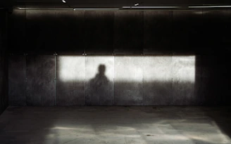 Abstract urban scene with sharp contrasts of light and shadow on textured walls.