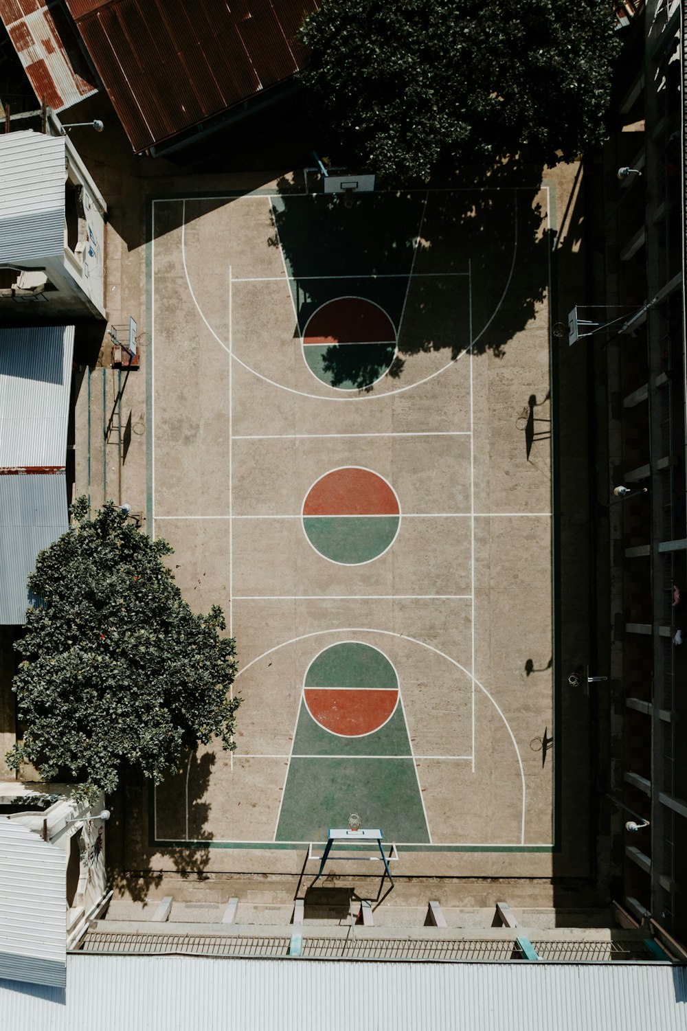 uma vista aérea de uma quadra de basquete com uma árvore