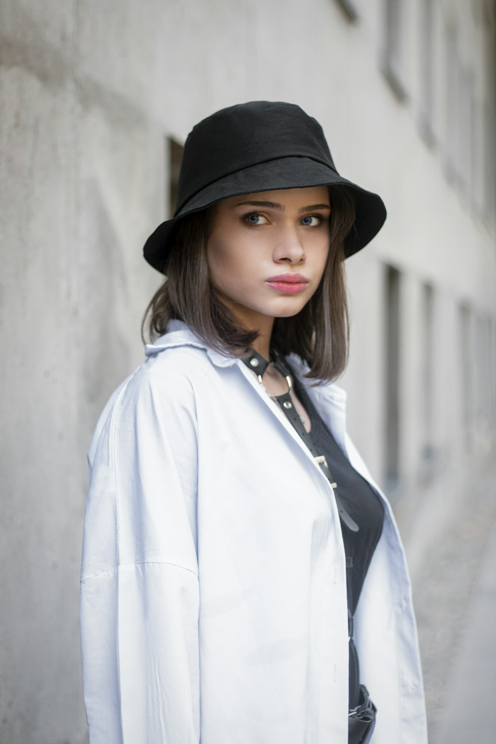 a woman wearing a white coat and a black hat