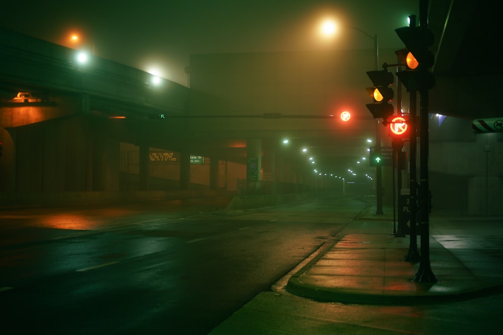 a foggy city street at night with traffic lights