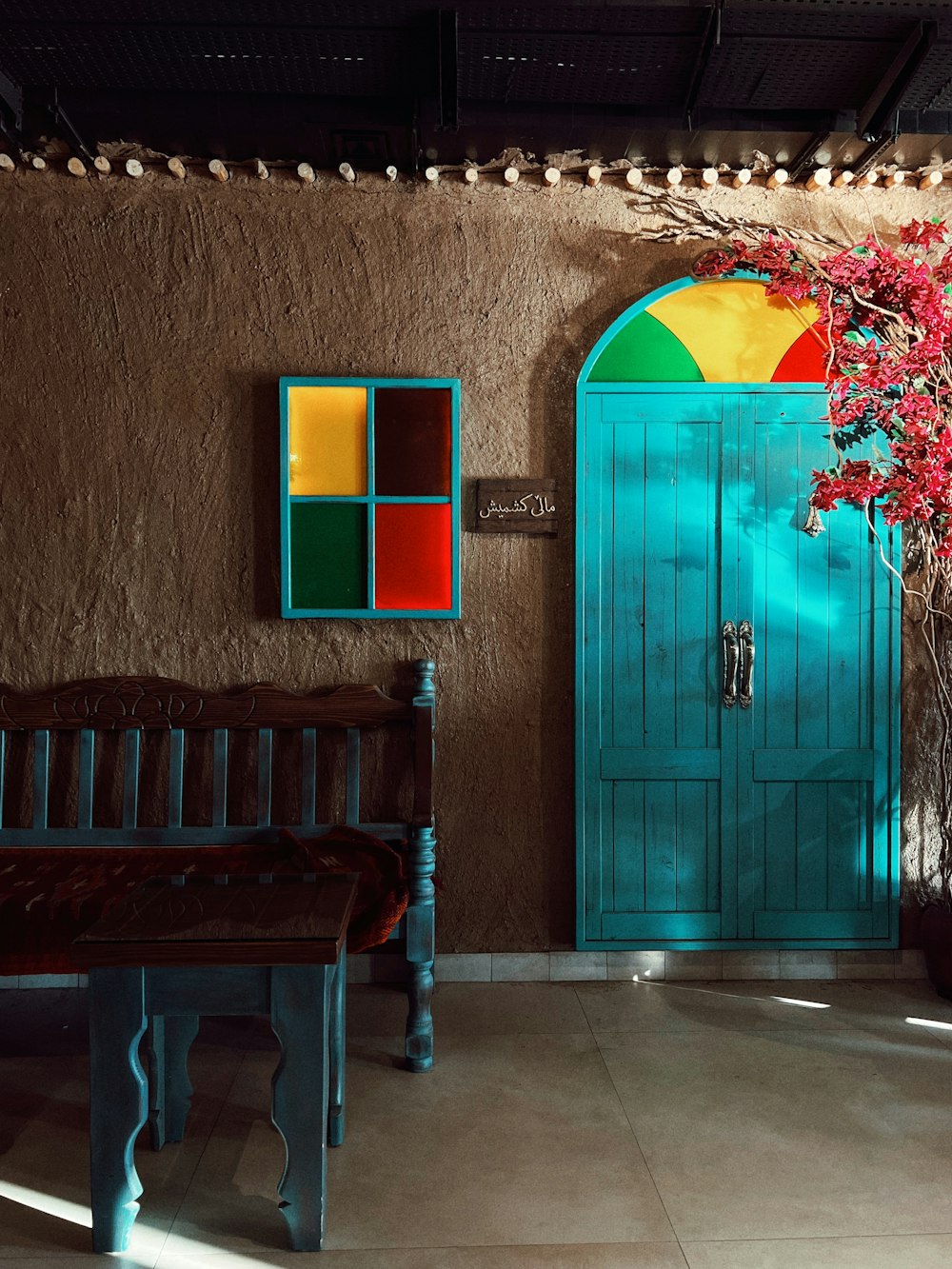 a wooden bench sitting in front of a blue door