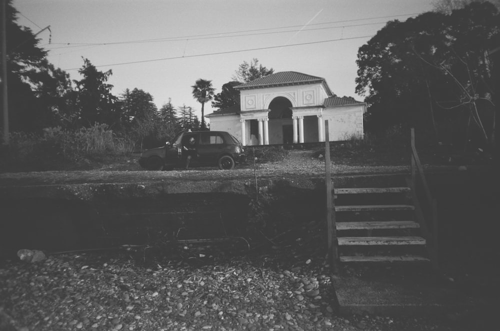 a black and white photo of a truck parked in front of a house