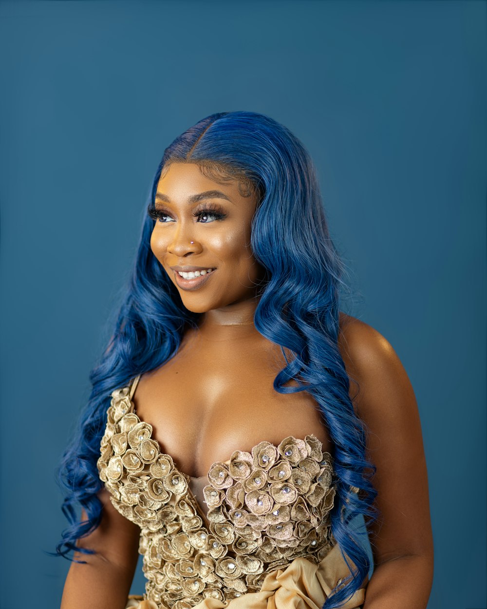 a woman with blue hair wearing a gold dress