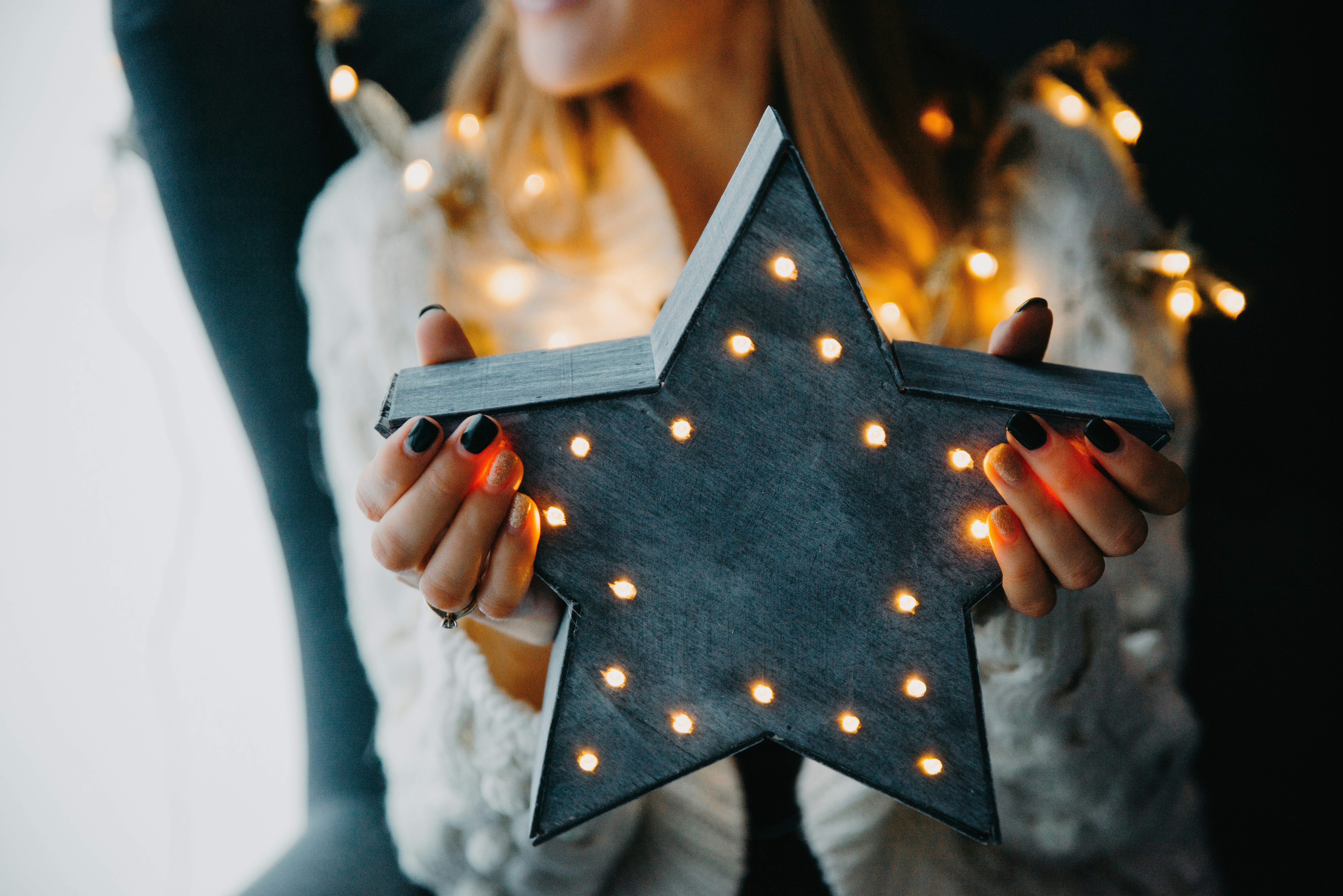 a woman holding a star shaped light up decoration