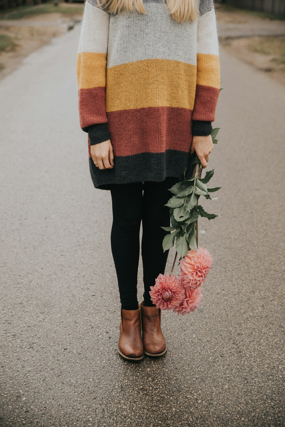 a woman in a striped sweater holding a bouquet of flowers